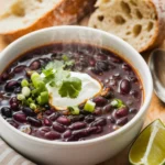 A cozy shot of a steaming bowl of purple black bean soup